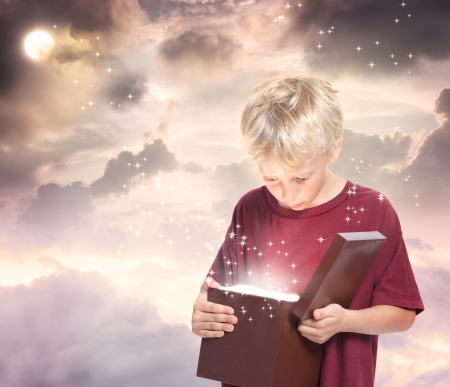 Happy Young Blond Boy Opening a Gift Boxの写真素材