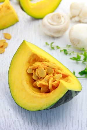 Kabocha pumpkin with mushrooms and herbs on white wooden boardの写真素材