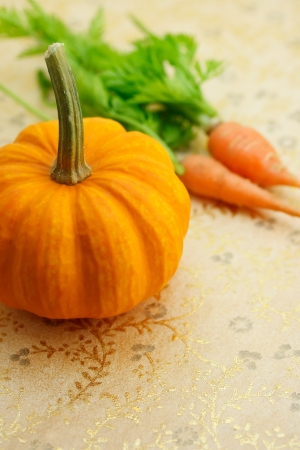 Orange miniature pumpkin with carrotsの写真素材