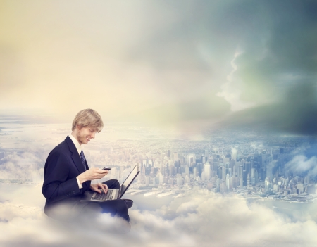 Young Business Man with Laptop and Phone on Top of the Cityの写真素材