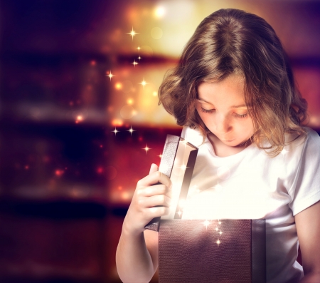 Happy Little Girl Opening a Present Boxの写真素材