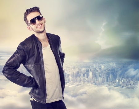 Young handsome man wearing sunglasses on top of the cityの写真素材