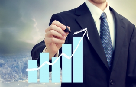 Business man with a chart showing growth with city backgroundの写真素材