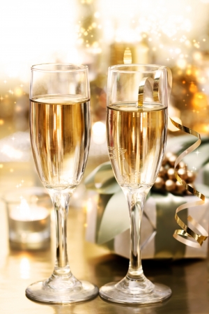 Shining champagne glasses with candles and gifts の写真素材