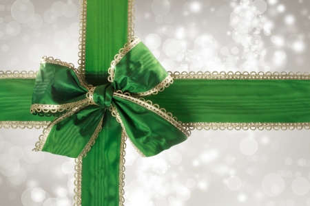 Green Bow and Ribbon with Silver Bokeh Lights Background の写真素材