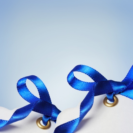 Price Tags with Blue Ribbons on Light Blue Backgroundの写真素材