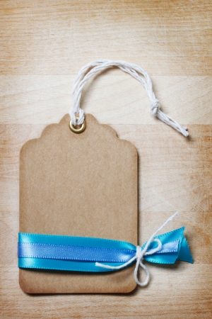 Handmade Price Tag with Ribbon and Decoration on Vintage Wooden Boardの写真素材