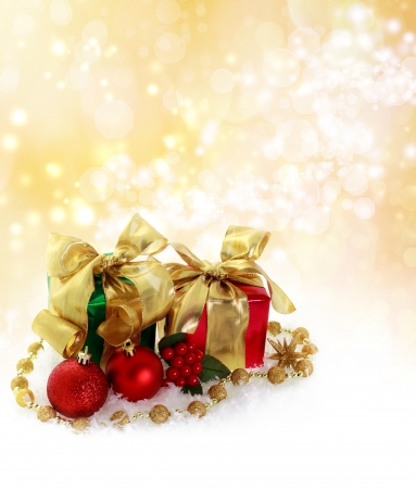 Red and green Christmas gifts over golden lights backgroundの写真素材