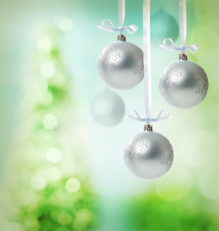 Christmas snowflake ornaments over green tree lights backgroundの写真素材