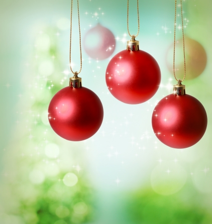 Christmas red ornaments over green tree lights backgroundの写真素材