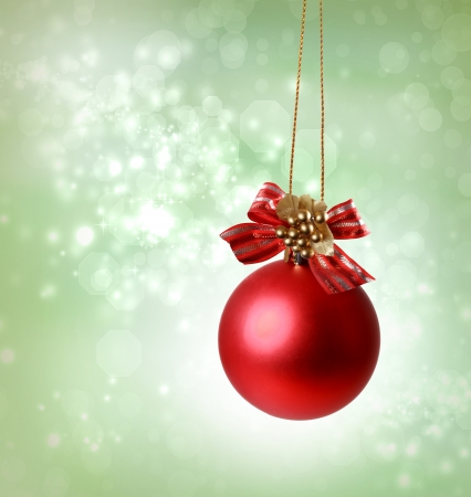 Christmas red ornaments over green tree lights backgroundの写真素材
