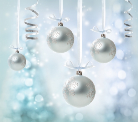 Silver Christmas Ornaments over glowing tree backgroundの写真素材