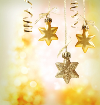 Christmas star ornaments over yellow orange lights backgroundの写真素材
