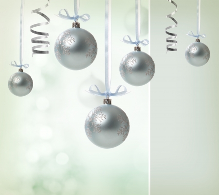 Silver Christmas Ornaments over glowing backgroundの写真素材