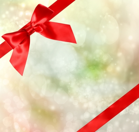 Red Bow and Ribbon with Green Bokeh Lights Background の写真素材
