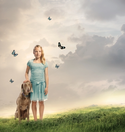 Young Blonde Girl with her Dog on a Magical Mountainの写真素材