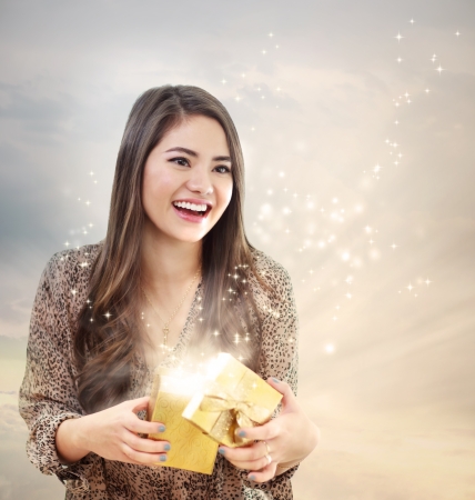 Girl Opening a Magical Golden Gift Box の写真素材