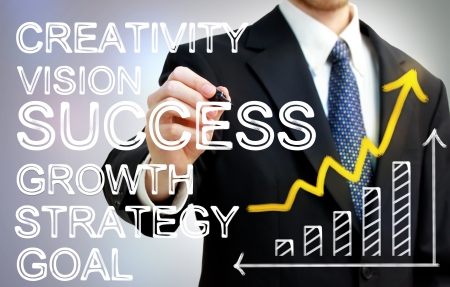 Businessman writing success concepts with rising arrow and bar graphの写真素材