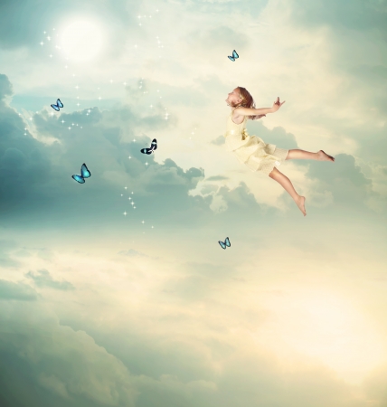 Little Blonde Girl Flying with Butterflies at Twilight の写真素材