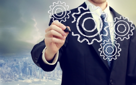 Businessman with gears - concepts of teamwork, efficiency, interlocking parts.の写真素材