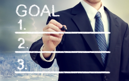 Businessman listing his goals with cityscape backgroundの写真素材