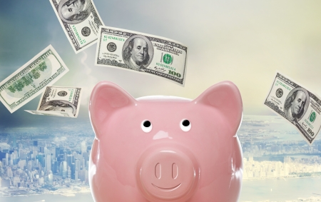 Piggy bank with hundred dollar bills above the cityの写真素材