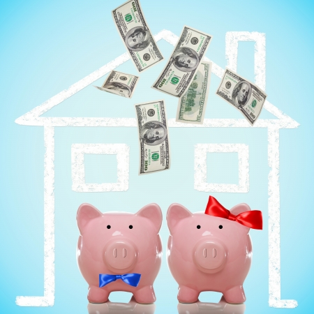 Piggy bank couple buying or dreaming of a new home with flying moneyの写真素材