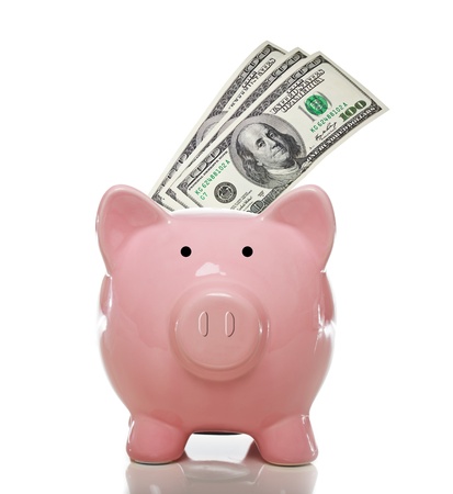 Pink piggy bank with 3 one hundred US dollar bills on a white backgroundの写真素材