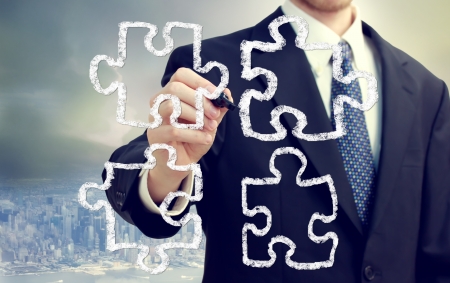 Businessman with puzzle pieces - concepts of strategy, creativity, and teamworkの写真素材