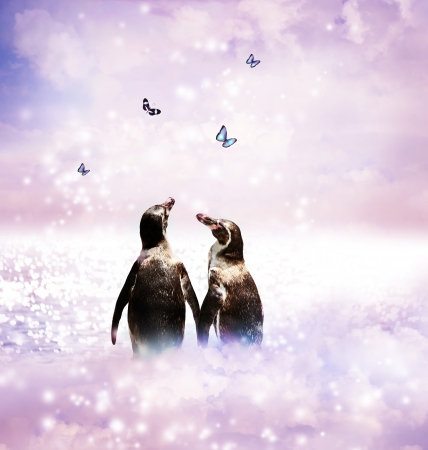Two Penguins holding wings in a fantasy nature landscape with butterfliesの写真素材