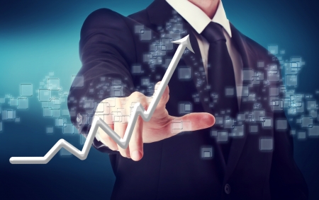 Businessman Touching a Arrow Indicating Growth on navy blue backgroundの写真素材