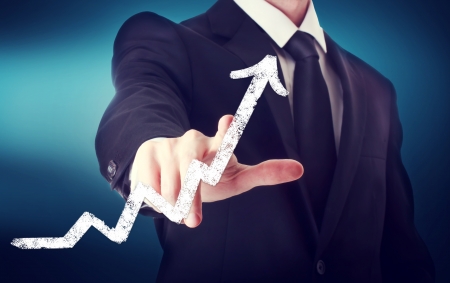 Businessman Touching a Arrow Indicating Growth on navy blue backgroundの写真素材