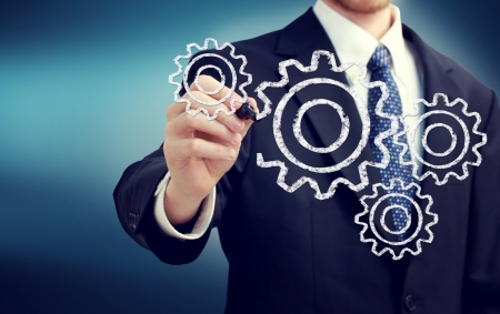Businessman with gears - concepts of teamwork, efficiency, interlocking parts.の写真素材