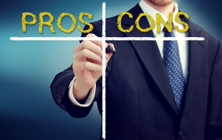 Business man writing pros and cons with a navy blue backgroundの写真素材