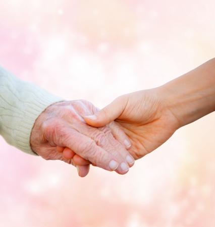 Senior Lady Holding Hands with Young Woman の写真素材