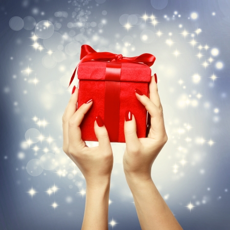 Woman's hands holding up red present box on Christmas の写真素材