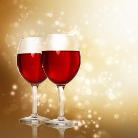 Two Red Wine Glasses on a Gold Sparkling Backdropの写真素材