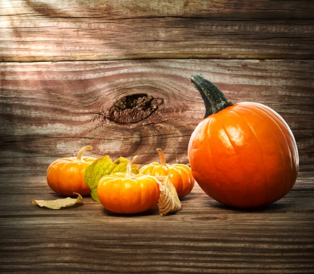 Pumpkins and squashes on rustic wooden boards with autumn leavesの写真素材