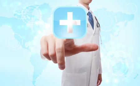 Medical Doctor pushing a blue cross icon over world map backgroundの写真素材