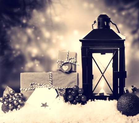 Christmas lantern with presents, ornaments and snow in sepia toneの写真素材