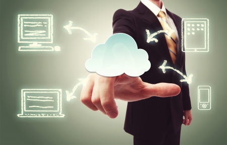 Businessman pressing a cloud icon with devices over vintage green backgroundの写真素材