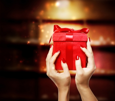 Woman displaying red present box on Christmasの写真素材