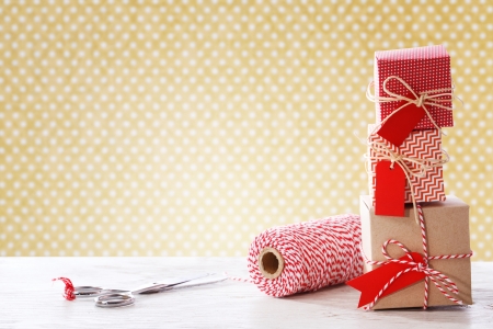 Handmade small boxes with scissors and twine spool on white wooden tableの写真素材