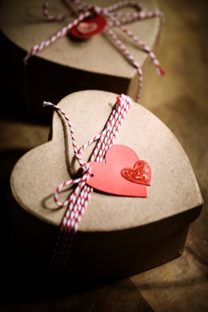 Gift boxes with handmade heart tags on wooden boardの写真素材