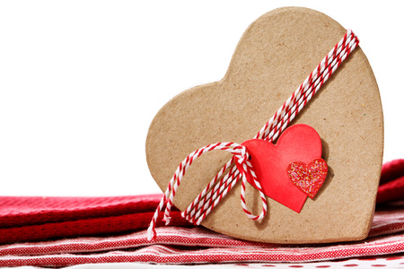 Heart shaped gift box with heart tag on red table clothの写真素材