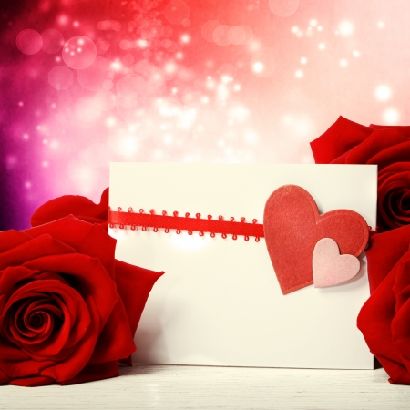 Hearts greeting card with beautiful red roses over abstract lights backgroundの写真素材