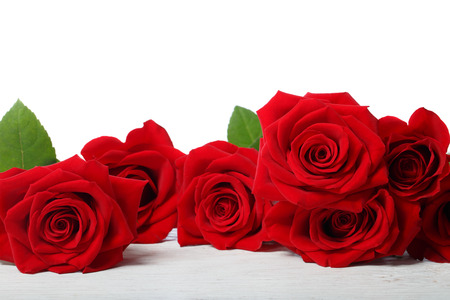 Beautiful red roses on white wooden tableの写真素材