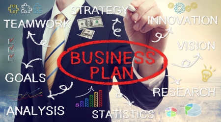 Businessman drawing business plan concepts with chalkの写真素材