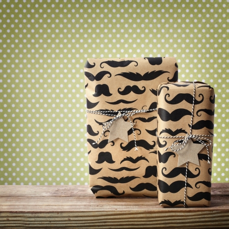Mustache pattered gift boxes with star shaped tags over polka dots backgroundの写真素材