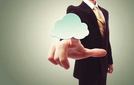 Businessman pushing a cloud icon over green vintage backgroundの写真素材